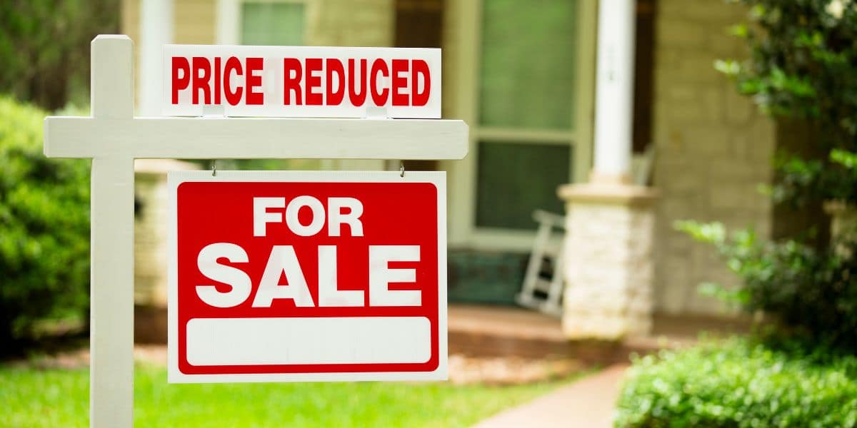 price reduced sign in front of house for sale
